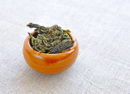 Dry herbal tea in a cup on sackclothの写真素材