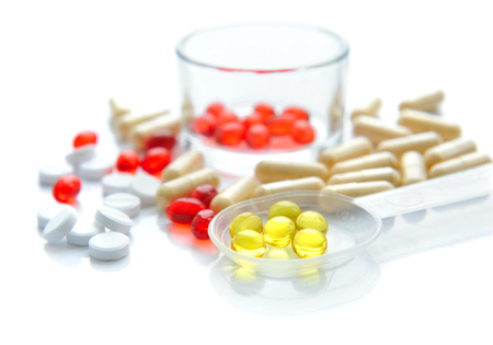 Yellow capsules are in a spoon on a background the color capsulesの写真素材