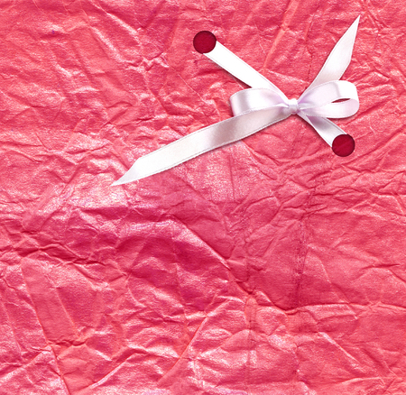 The white ribbon on the pink background of gift paperの写真素材
