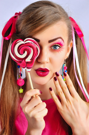 Beautiful girl with creative makeup with colorful lollipopの写真素材