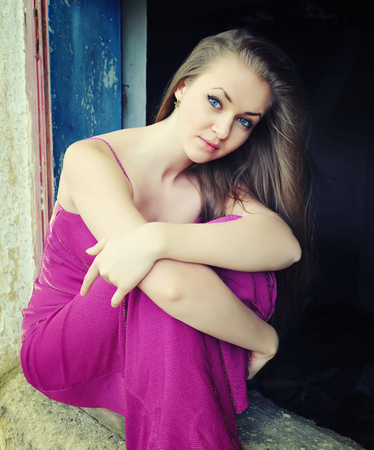 Young beautiful girl in a purple dress on a grange backgroundの写真素材