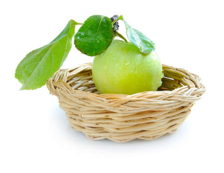 Fresh green apple in a little basket on a white backgroundの写真素材