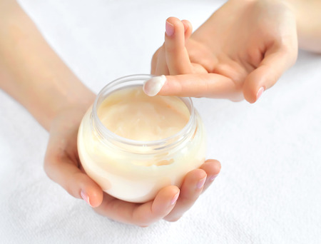Beautiful woman hands with cream. Focus is on a fingerの写真素材