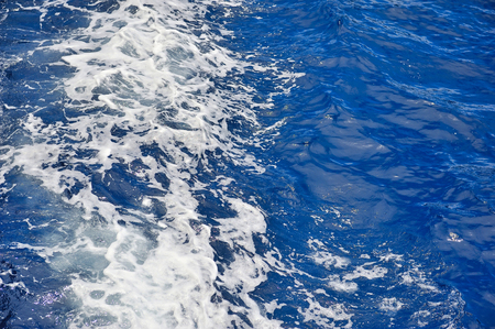Blue sea water surface in motion with foamの写真素材