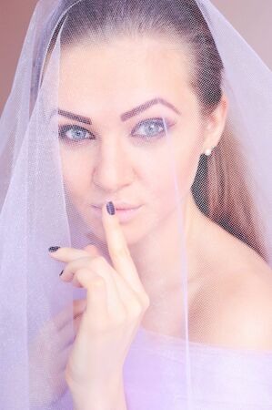 Portrait of a young beautiful woman in lilac veilの写真素材