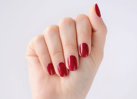 Closeup of hands of a young woman with red manicure on nailsの写真素材