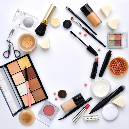 Makeup brush and decorative cosmetics on a white background with empty space in the middle. Top viewの写真素材