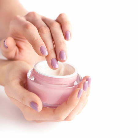 Hands of a woman with pink manicure with creamの写真素材