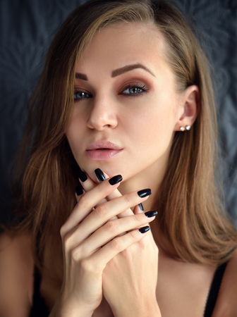 Portrait of a beautiful young woman with long hair looking at camera.の写真素材