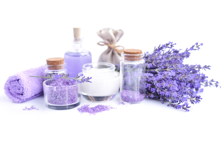 Spa composition with flowers of lavender, cream, salt and bottle of essential oil on a white backgroundの写真素材