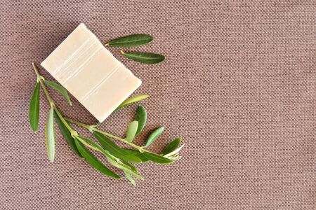Handmade soap bars and olive branches on gunny background. Top viewの写真素材