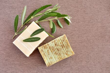Handmade soap bars and olive branches on fabric background. Top viewの写真素材