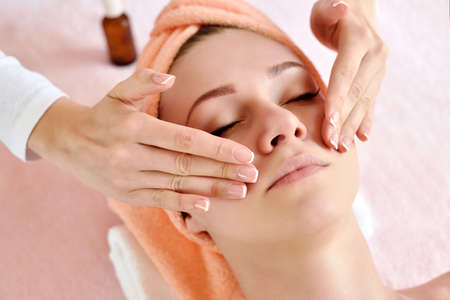 Beautiful woman receiving massage from female therapist in spa. Beauty wellness conceptの写真素材