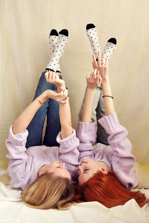 Two young girls are lying and talking down with legs upの写真素材