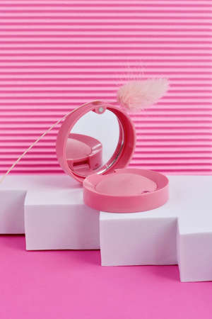 Round Blush in pink box with mirror on podium on a pink background. Cosmetic products.の写真素材