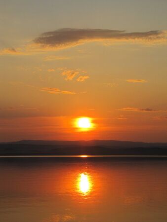 the sun sits down in the lakeの写真素材