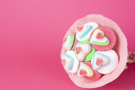 bouquet of marmalade and sweets in pink packaging on a pink backgroundの写真素材