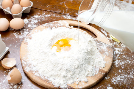 Making dough from eggs and milk. Cooking and home concept