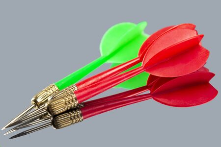 Red and green darts on a mirror background. Hit the targetの写真素材