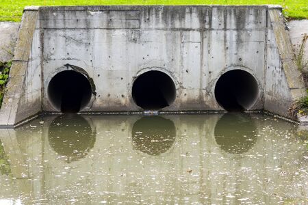 A drain pipe or sewage or sewage discharges waste water into a river. Wastewater or domestic wastewater or municipal wastewater that is a product of a community of peopleの写真素材