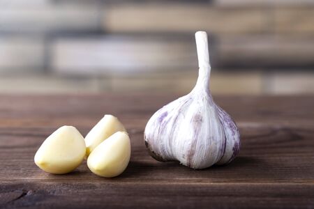 garlic on a wooden tablegarlic head and cloves on a wooden brown table. Healthy spices, healthy foodの写真素材