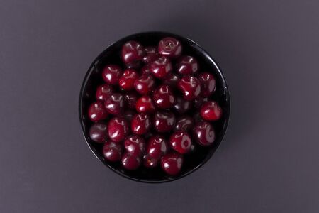 cherry in a black plate on a dark background.の写真素材