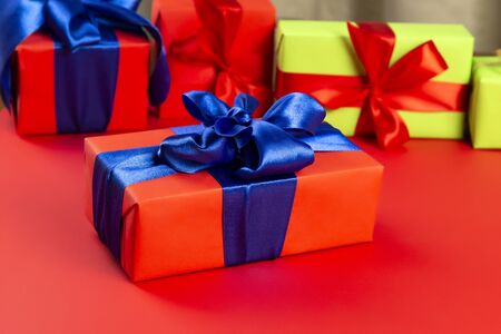 Red gift box with blue bow box on a red background near other gifts, christmas composition.の写真素材