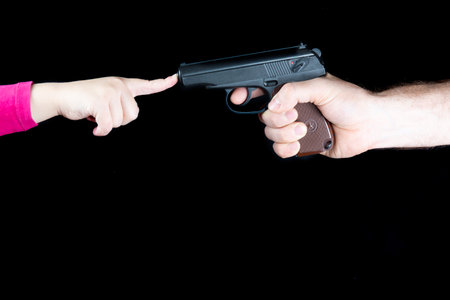 Male hand with a weapon against a child s hand, stop the weapon, stop the war.