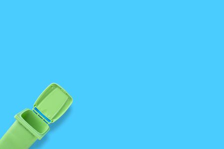 Green dumpster on a blue background, top view, space for text.の写真素材