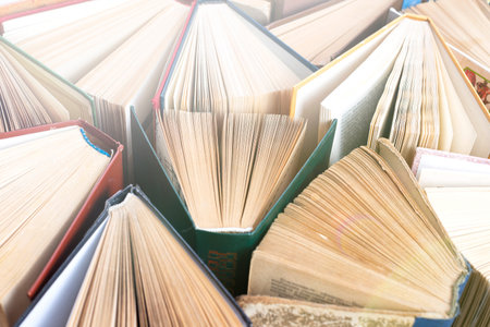 Old and used hardback books or text books seen from above. Books and reading are essential for self...