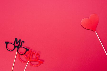 Carnival celebration concept. Black and red mask with a heart on a red background. Space for text. View from above.の写真素材