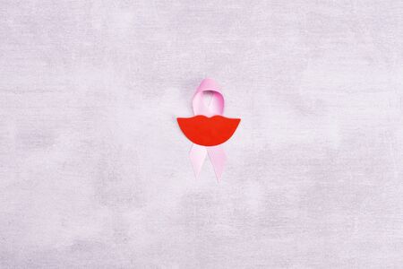 Healthcare and medicine concept - pink breast cancer awareness ribbon with paper gray background, flat wow red smile, layout, top view.の写真素材