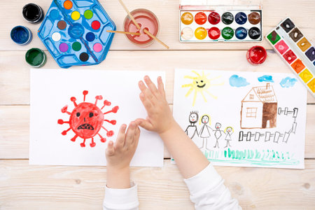 A child draws a coronovirus and his family on a piece of paper. Coronovirus and family at home. The...