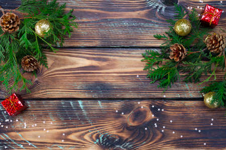 Christmas composition toys, gifts and branches of a Christmas tree frame on wooden background.の写真素材