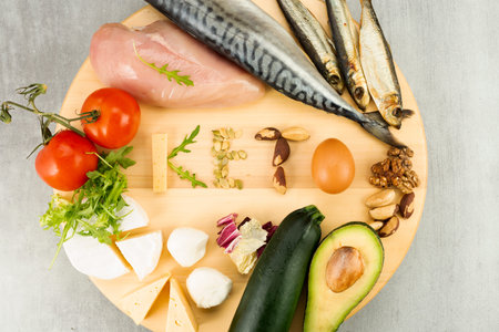 Ketone diet foods on a gray background. The word keto from ketogenic diet foods.