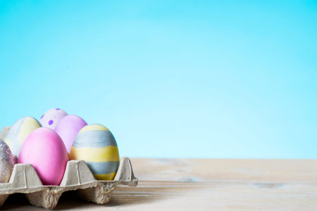 Colorful easter eggs on a stand on a table on a blue background
