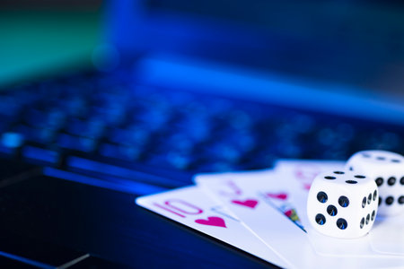 Online gaming platform, casino and gambling business. Cards and dice on laptop keyboard, toned in blue.の写真素材