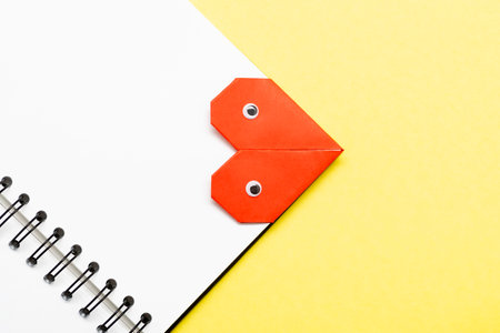 Bookmark heart with eyes for a book on a yellow background close up.の写真素材