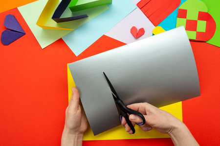 DIY instruction. Step by step guide. The process of making a paper heart from yellow and gray...