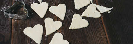 Heart stencil for cookies. Heart-shaped holes. Raw dough in the shape of a heart.の写真素材