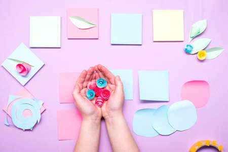 DIY instruction. Step by step guide. The process of making paper flowers from colorful postcard stickers. Little girl preparing a card for mothers day.の写真素材