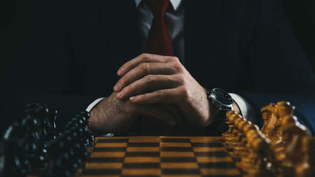the concept of strategy and business planning, a businessman at a chessboard with figures lined up in their places, strategy and tactics, readiness for battleの写真素材