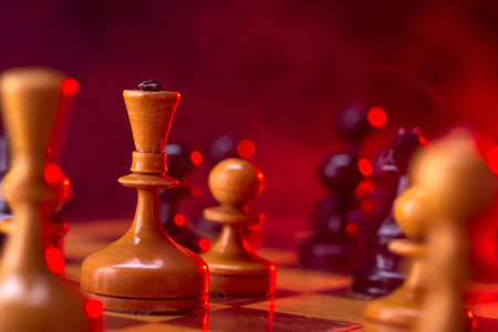 Chess fight, chess pieces on the board, toned in red. Battle fire and smokeの写真素材