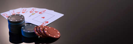 Chips and cards for playing in a casino on a black background with reflection. The concept of gambling and entertainment. Casino and poker.の写真素材