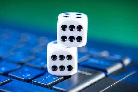 Online gaming platform, casino and gambling business. Dice on laptop keyboard on green background.の写真素材