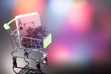 Casino chips and cards for playing the casino in a cart on a background with bokeh. Online gambling. Dependence.の写真素材