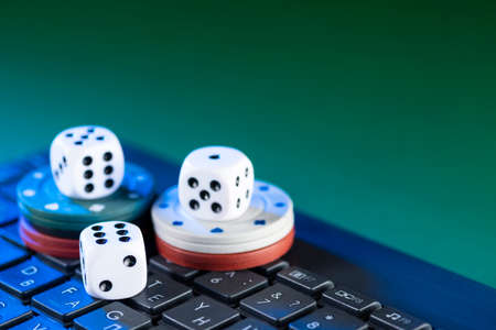 Online gaming platform, casino and gambling business. Dice on laptop keyboard on green background.の写真素材
