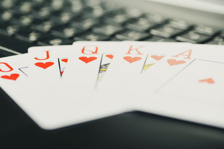 Online gaming platform, casino and gambling business. Cards, dice and multi-colored game pieces on laptop keyboard.の写真素材