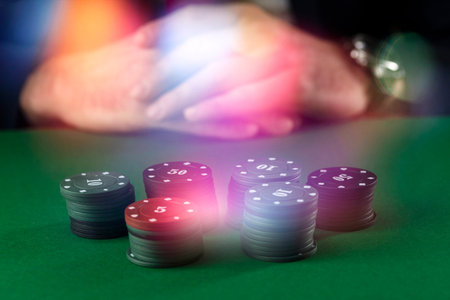 Businessman at green gaming table with casino chips.