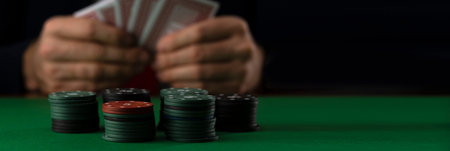 Businessman at green playing table with gambling chips and cards playing poker and blackjack in...